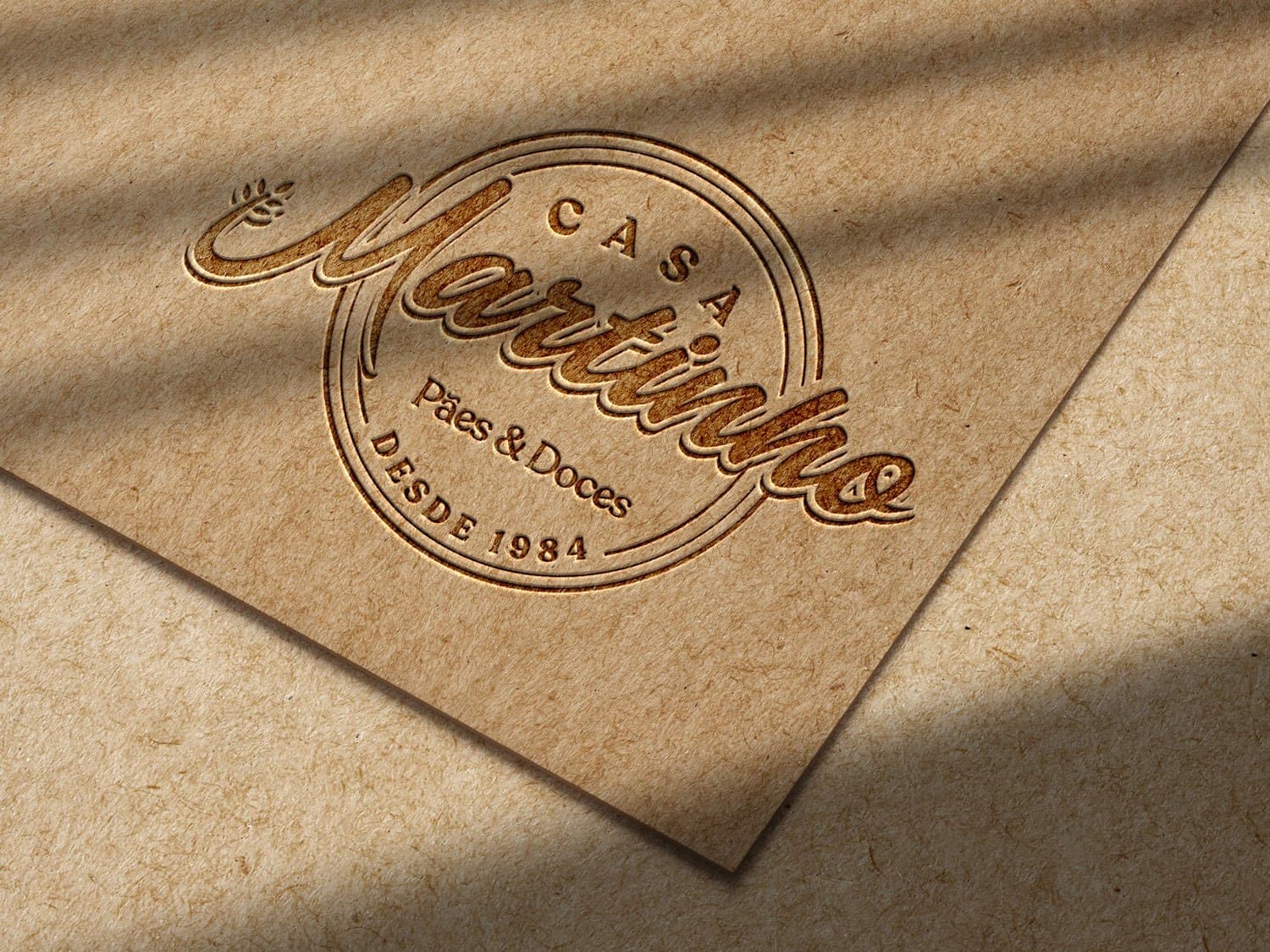 Logotipo Casa Martinho gravado em relevo sobre papel kraft