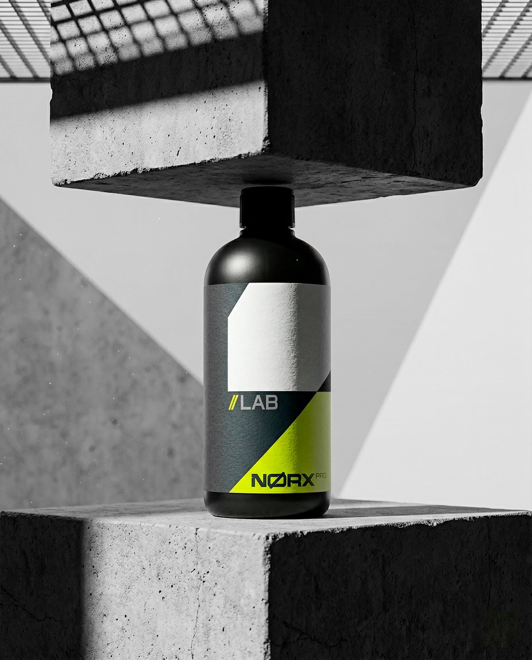 Frasco Nørxx LAB sobre blocos de concreto, em estúdio preto e branco